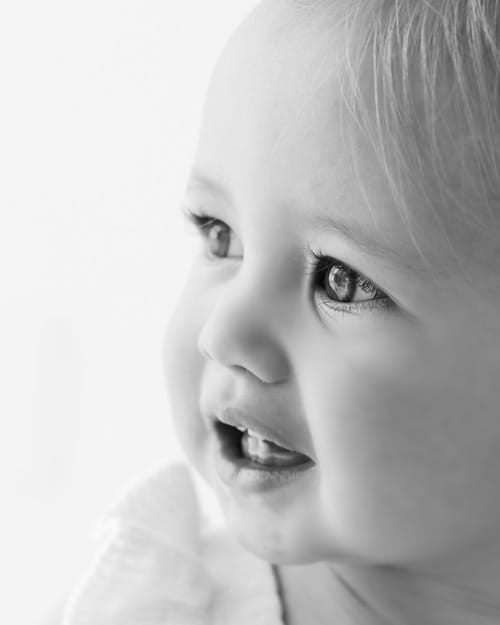Close portrait of a laughing baby with a first tooth showing