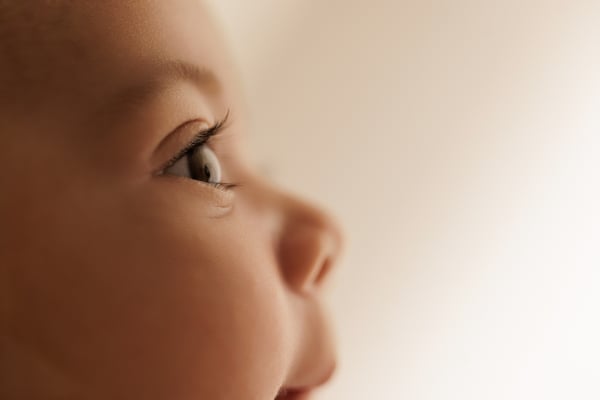 Very close view of a baby's face in profile, the eye and cheek in focus