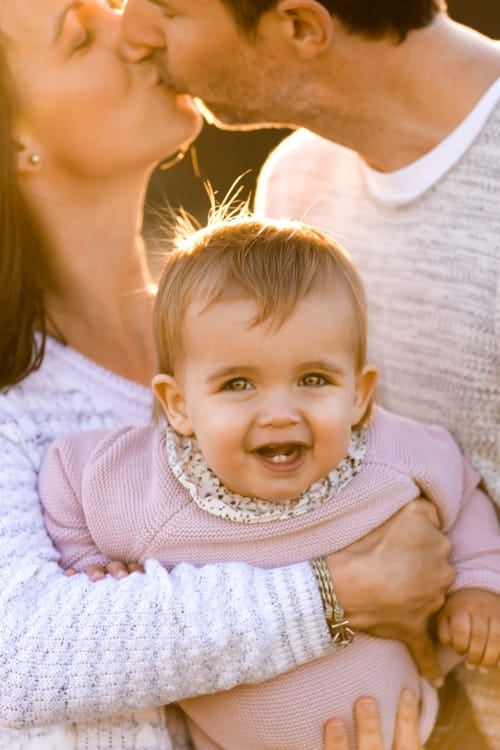 Baby in her mother's arms, backlit by low evening sun