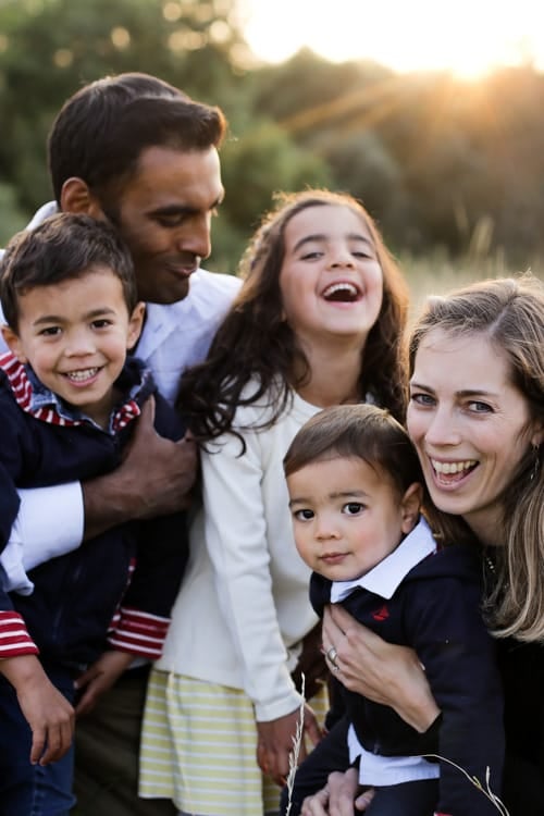 A family of five pressed close together, all laughing