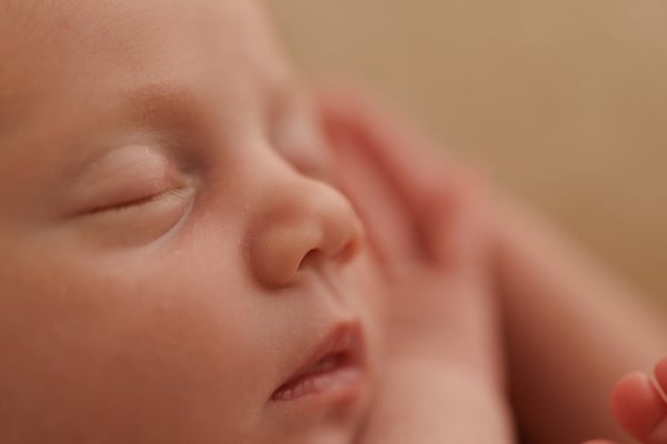 Close view of a sleeping newborn's cheek and closed eye