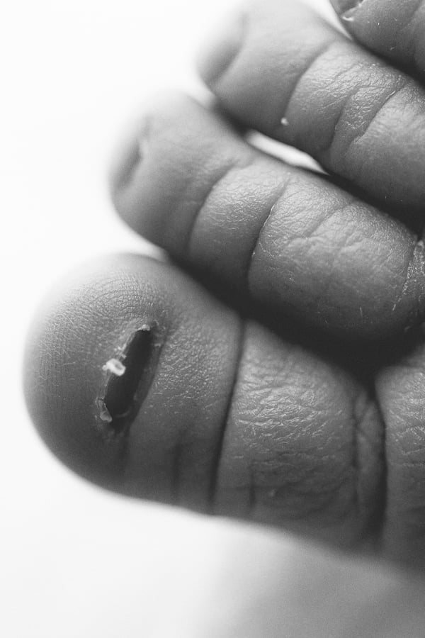 Extreme close-up of a newborn's curled fingers in black and white