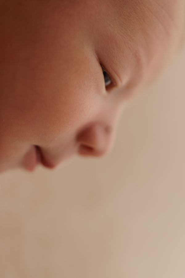 Very close view of a newborn's open eye and nose