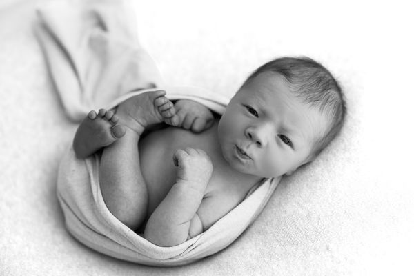 Extreme close-up of a newborn's closed fist, in black and white