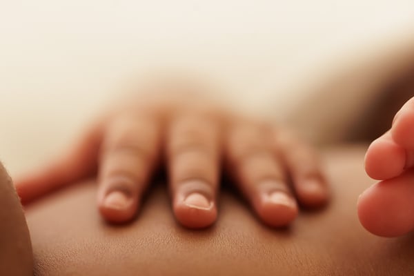 Extreme close-up of a newborn's hand resting on skin