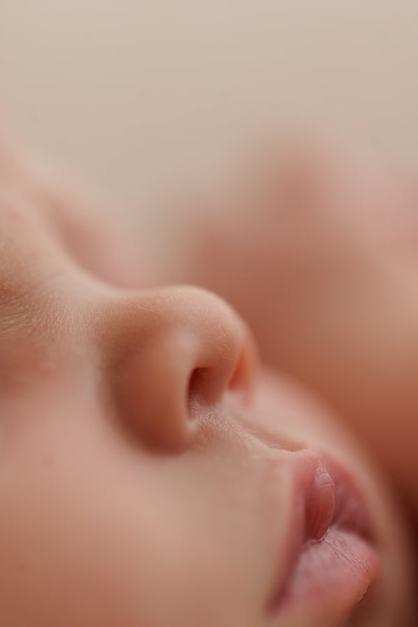 Macro of a sleeping newborn's nose and lips, seen in profile