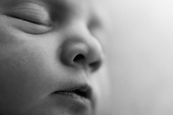 Extreme close-up of a sleeping newborn's face, in black and white